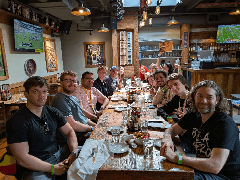 Accelerator participants gathered around a long table at a restaurant during TwitchCon San Diego